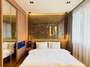 a bedroom with a large bed and a mirror at The Prestige Living Bangkok at Sathorn-Chan in Bangkok