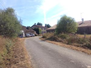 a road with cars parked on the side of a house at La Brionniere in Aizenay