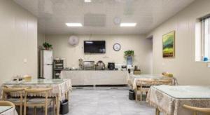 a room with tables and chairs and a tv on the wall at City 118 Selected Hotel Xi'an Fengcheng Nan Road in Xi'an