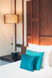 a bedroom with a bed with blue pillows at HOTEL KONARK in in Vastral