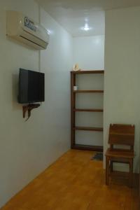 a living room with a tv and a chair at 6227 Guesthouse in San Juan