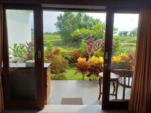 an open door with a view of a garden at Luka's Place - 1 bedroom in Cemagi +3 photos