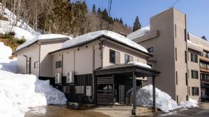 a building covered in snow with snow around it at Ponshu Hotel Suimu in Tokamachi
