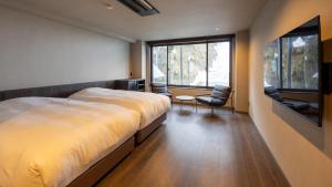 a bedroom with a large bed and a large window at Ponshu Hotel Suimu in Tokamachi