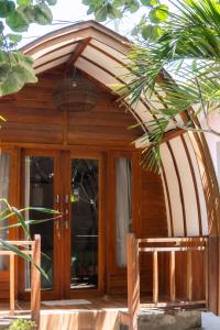 クタにあるLost Inn Kuta Capsule Hostelのガラスのドアとバスケットが付いた木造の家