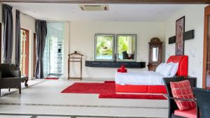 a bedroom with a red bed and a red rug at The Diamond Villa - Private Pool, Jacuzzi & Views in Pantai Cenang +50 photos