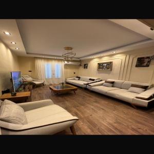 a large living room with couches and tables at شقة عائليةvip in Cairo