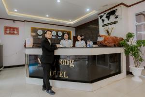 a man in a suit standing at a counter at Vilayvong Hotel in Vang Vieng +52 photos