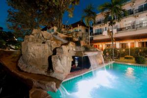 a swimming pool with a waterfall in a resort at Vilayvong Hotel in Vang Vieng