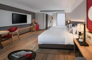 a hotel room with a large bed and a desk at Echeng Hotel Nanning the Mixc Convention in Nanning