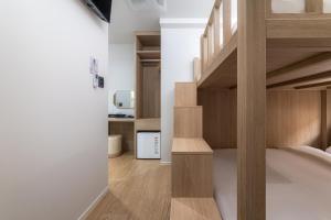 a bedroom with a bunk bed with wooden stairs at Hi Stay Myeongdong in Seoul