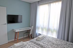 sypialnia z łóżkiem, biurkiem i telewizorem w obiekcie LoveSopot Luxury Garden Apartment w mieście Sopot