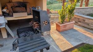 Una parrilla con carne al lado de un banco en Agriturismo Amici Miei, en Marliano