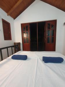 2 almohadas azules encima de una cama blanca en Cinnamon Edge Mirissa, en Mirissa