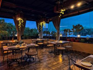 a restaurant with tables and chairs in a room with windows at RION - A Boutique Hotel in Udaipur