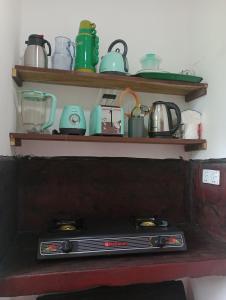 a shelf with cups and pots and pans on it at Lakshmi Villa in Aluthgama