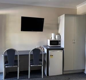 a room with a table with two chairs and a microwave at Hotel Theodore in Theodore
