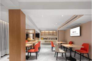 a dining room with tables and red chairs at Borrman Hotel Guilin Two Rivers and Four Lakes Beiji Plaza in Guilin