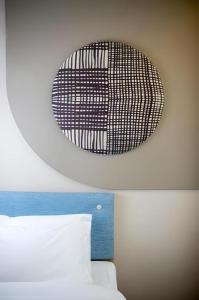 a black and white clock above a bed at Home Inn Hotel Chengdu Gaoshengqiao Subway Station in Chengdu