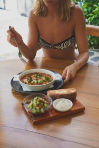 a woman sitting at a table with a plate of food at Terra Resort in Ahangama