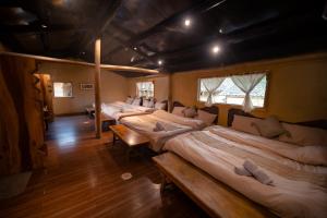 a row of beds in a room with wooden floors at Homestay & Cafe Cực Bắc in Dồng Văn