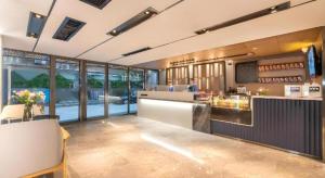 a restaurant with a counter and a bar with windows at Echarm Hotel Guangzhou Tiyu West Raod Metro Station in Guangzhou