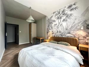 a bedroom with a bed with a floral mural on the wall at Kotlarska 39 Apartment - Self Check-In 20h in Wrocław