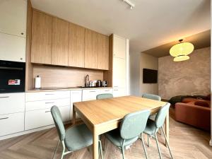 a kitchen and dining room with a wooden table and chairs at Kotlarska 39 Apartment - Self Check-In 20h in Wrocław