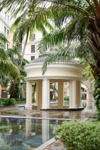 a building with a pool in a courtyard with palm trees at Hygg Hotel Phu Quoc in Phu Quoc