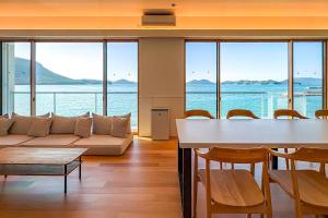 a living room with a couch and a table and chairs at Nagisato Villa Clover in Takamatsu
