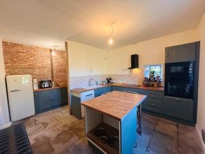 Una cocina con gabinetes azules y un refrigerador blanco. en Grande maison Albuconis, 