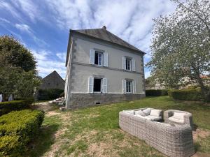 Una casa vieja con un sofá delante. en Grande maison Albuconis, 