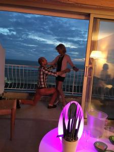 a woman and a man standing on a balcony at Le Rayon Vert in Le Touquet-Paris-Plage