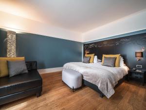 a bedroom with a large bed with a blue wall at Royal St. Georges Hotel Interlaken - MGallery Collection in Interlaken