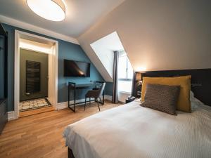 a bedroom with a bed and a desk in a room at Royal St. Georges Hotel Interlaken - MGallery Collection in Interlaken