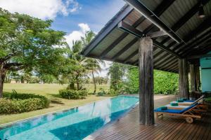 una piscina al aire libre con pérgola y sillas en 4BR Laguna Golf View Pool Villa Retreats Phuket, en Laguna Phuket