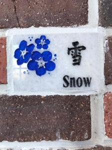 a snow sign with blue flowers on a sidewalk at 墾丁勿忘我城堡莊園 in Hengchun