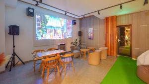 a room with a table and chairs and a green floor at Gangneung Cresostay pension in Gangneung
