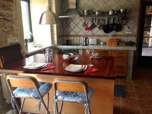 a kitchen with a wooden table with two chairs at Casa El Fontán in Moaña