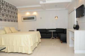 una habitación de hotel con una cama y un sofá en Fiesta Bahiana Club Hotel, en Irecê