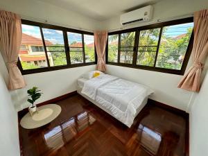 a bedroom with a bed in a room with windows at Stand alone 3 bedrooms detached house inside Bangkok in Ban Klong Plad Kriang