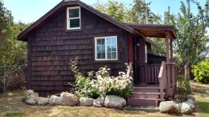 ein kleines Haus mit einer Veranda und einem Fenster in der Unterkunft Jones Cabin in Friday Harbor