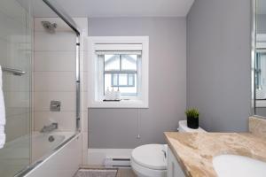 ein Badezimmer mit Toilette, Waschbecken und Dusche in der Unterkunft Brand New Stylish 2 bedrooms Suite in Shaughnessy in Vancouver