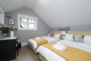 ein Schlafzimmer mit zwei Betten mit Handtüchern darauf in der Unterkunft Brand New Stylish 2 bedrooms Suite in Shaughnessy in Vancouver