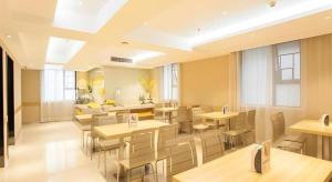 a restaurant with tables and chairs and a kitchen at City Comfort Inn Nanning Chaoyang Square Metro Station in Nanning
