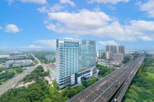 無錫市にあるダブルツリー バイ ヒルトン ウーシーの大きな建物と高速道路の空中風景