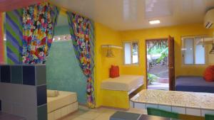 a room with two beds in a room with yellow walls at Sunset Hill Lodge in Bora Bora