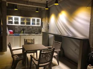 a dining room with a table and chairs and a kitchen at Laverne Hotel in Ho Chi Minh City