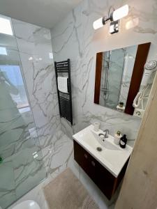 Un baño con lavabo, ducha y espejo. en Casa Matteo - Rustic & cosy getaway in Zărnești, en Zărneşti 48 fotos más