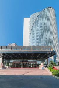 a large building with a bridge in front of it at Hundred Hotel Qingdao in Qingdao